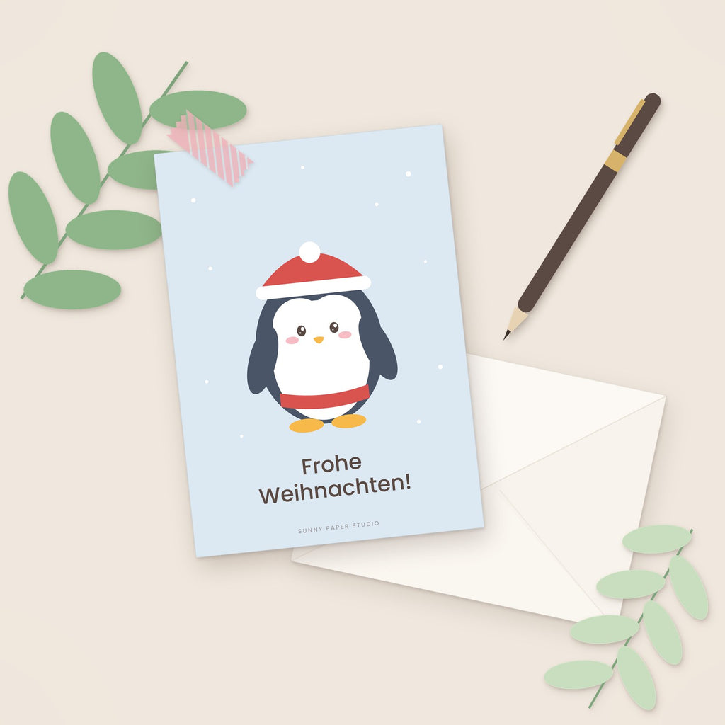 Weihnachtskarte Pinguin auf dem Schreibtisch mit Stift
