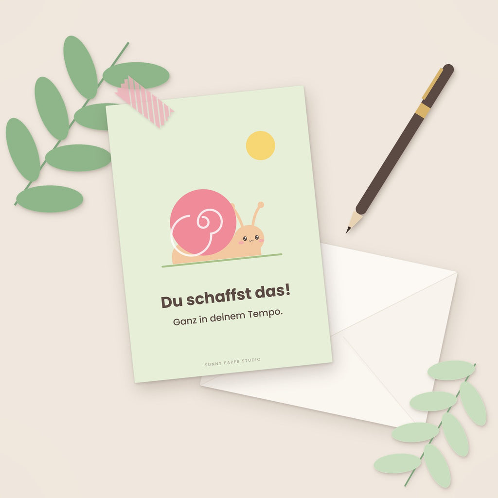Mutmacher-Karte Schnecke auf dem Schreibtisch mit Stift