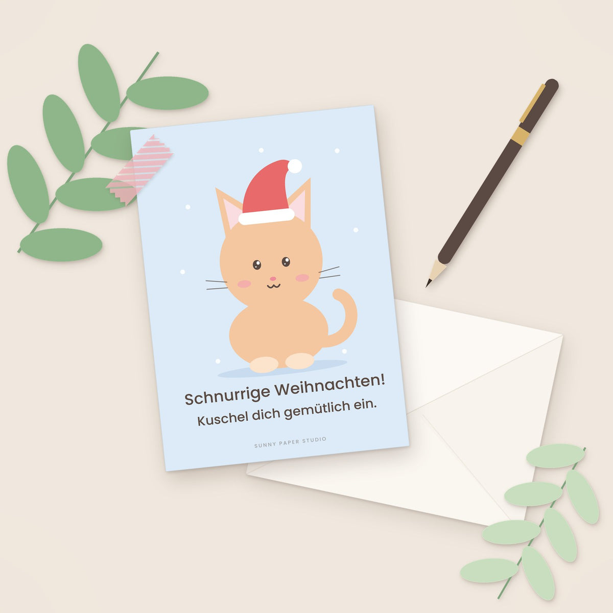 Weihnachtskarte Katze mit Weihnachtsmütze auf dem Schreibtisch mit Stift