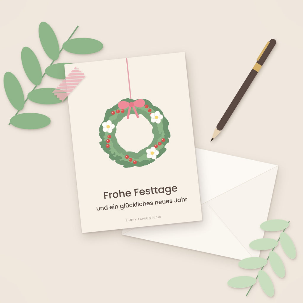 Weihnachtskarte Winterkranz auf dem Schreibtisch mit Stift